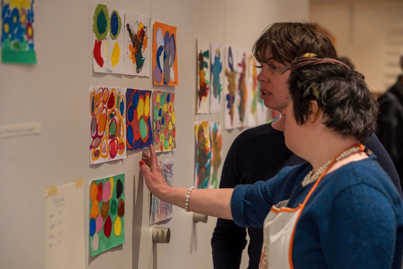 Zwei Personen bei der Ausstellung der Farb-Werkstatt betrachten Bilder